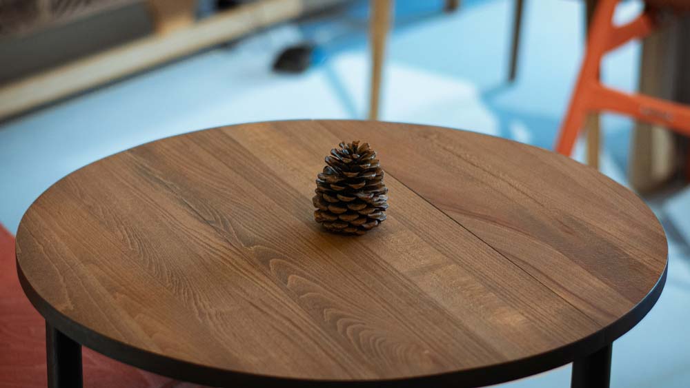 A custom wooden coffee table with a pinecone on top
