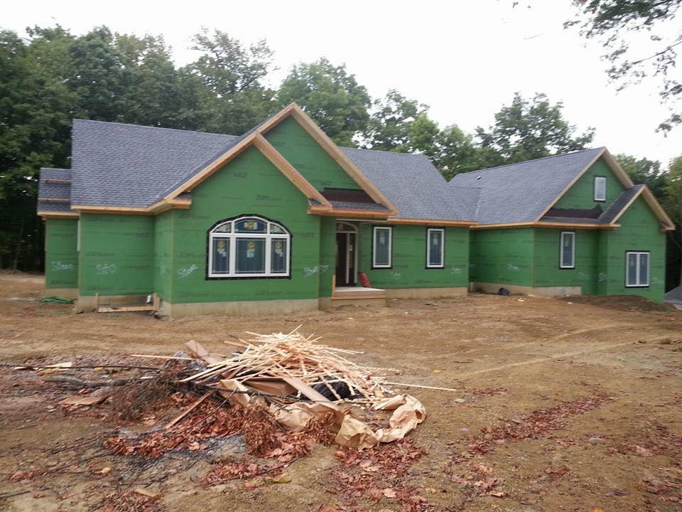 A half-built house with a pile of construction waste in the foreground.